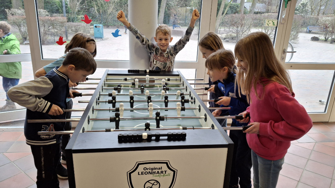 Die Kinder der FRS spielen mit dem neuen Tischkicker.